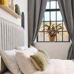 A double bed with a view out of a window at JÖRO Oughtibridge Mill.