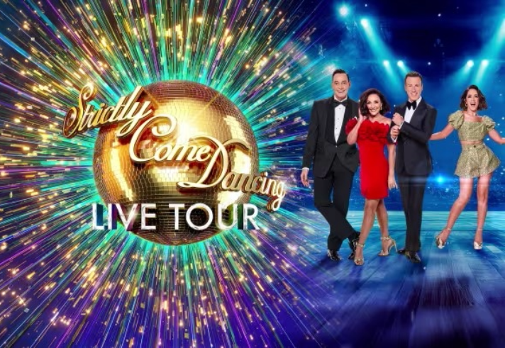 Promotional graphic for the “Strictly Come Dancing Live Tour.” It features a large golden disco ball with the show’s logo in elegant script, surrounded by colourful light bursts. Four people in formal and dance attire stand on a stage with bright blue spotlights in the background.