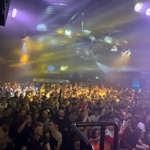 A crowd dances in a huge nightclub.