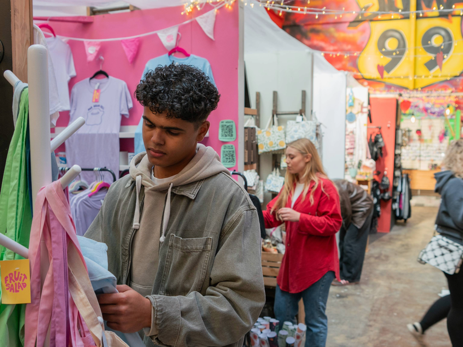 People looking at various stalls at an indoor market.