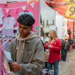 People looking at various stalls at an indoor market.