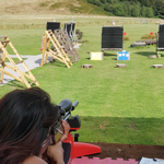 A person aiming a rifle at a target on a shooting range.