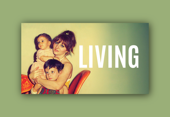 A woman, looking straight at the camera, sits on on chair holding two small children.