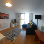 Spacious living room with a comfortable settee and a dining table with chairs.