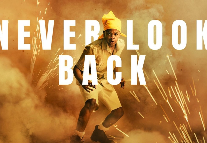 Promo image for 'Never Look Back' with a man surrounded by smoke and explosions.
