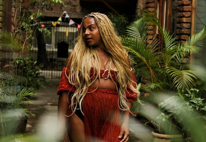A woman stands in a room that is filled with all sorts of exotic plants.