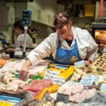A stall holder sorting their display of fish and meat at The Moor Market.