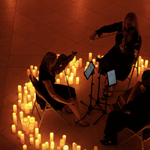 Simply Strings performing in a circle of candles.