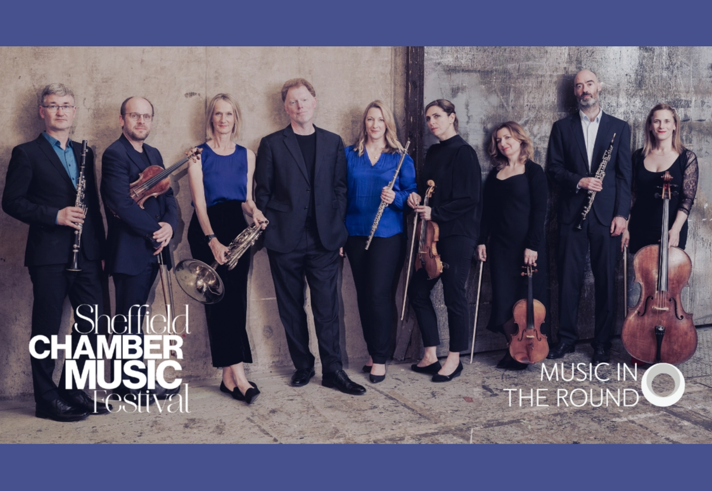 Members of Ensemble 360 stand against and old wall, holding their instruments.