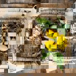 A hand basket with dried flowers and lemons in it.