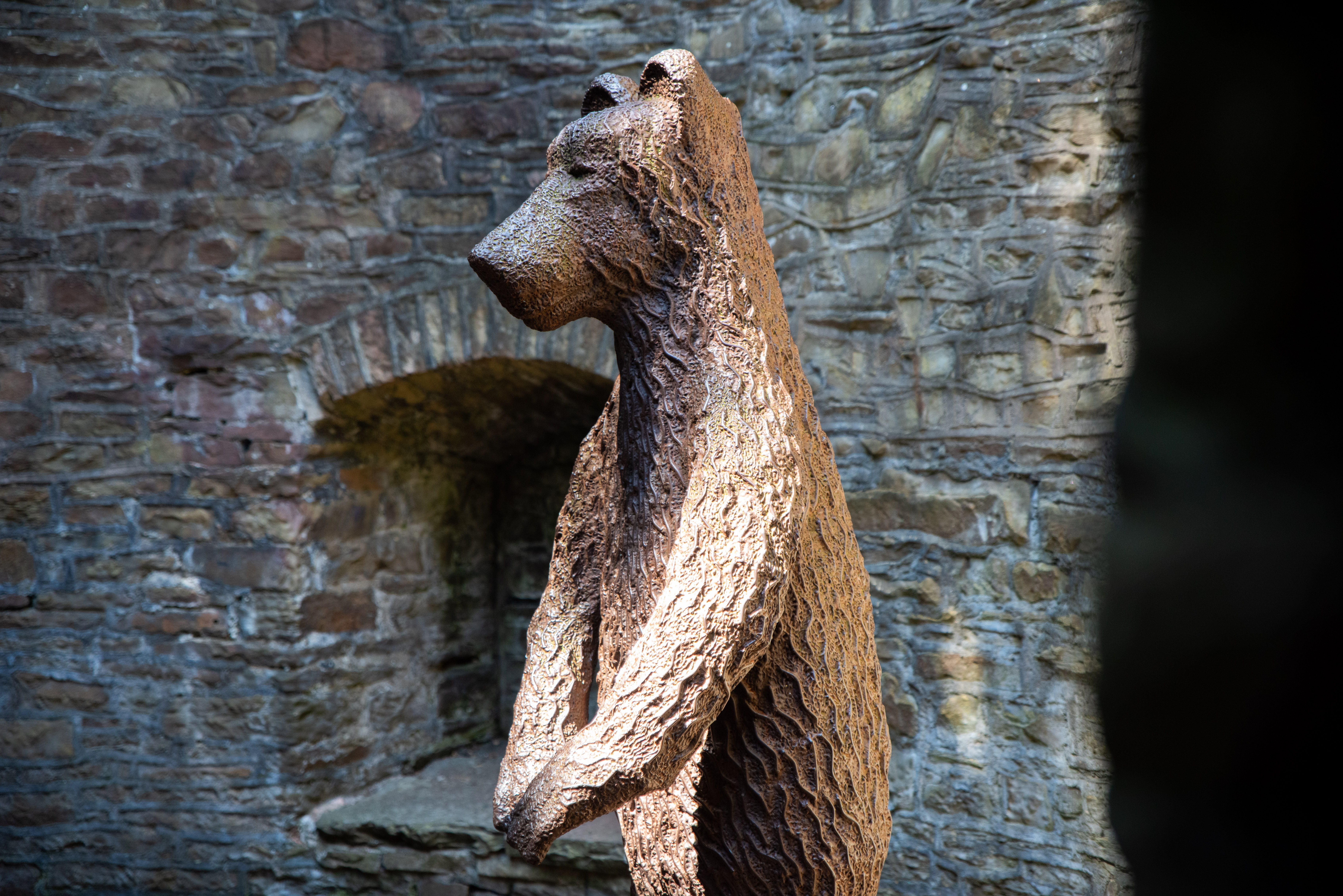 A bronze statue of a bear in the bear pit at Sheffield Botanical Gardens.