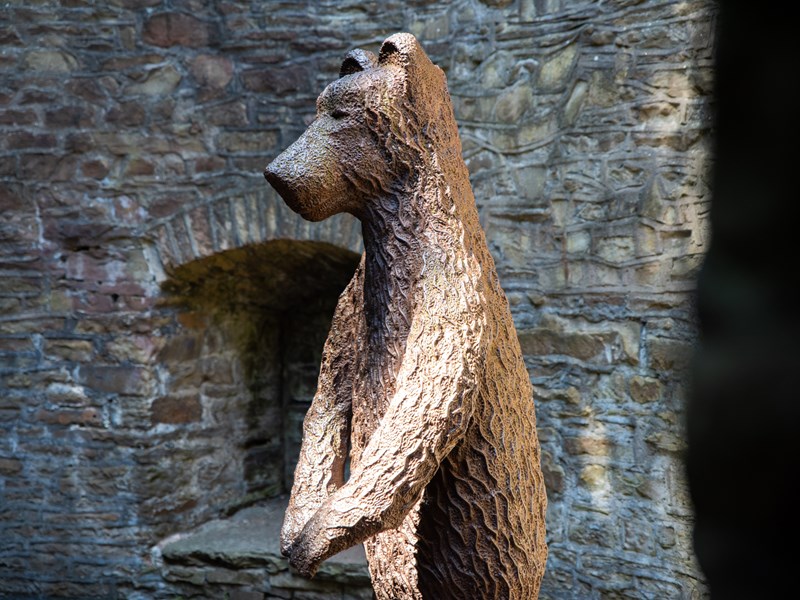 A bronze statue of a bear in the bear pit at Sheffield Botanical Gardens.