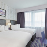 Bedroom featuring one double bed and one single bed, with modern furnishings.