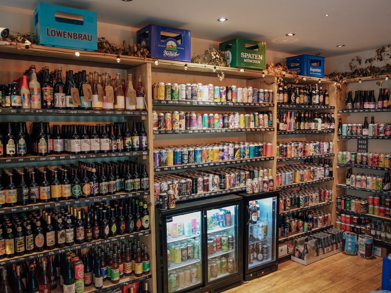 Inside Turner's Bottle Shop & Tap, the walls are taken up with shelving and chiller cabinets, all filled with bottles and cans.