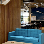 An interior shot of Cobo showing a wooden partition and a blue sofa and a low coffee table.