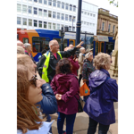 A tour guide talks to a group of people on a tour in Sheffield.