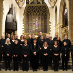A picture of The Sterndale Singers standing in front of an alter in a church.