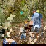 A family, in the woods, on an Easter Egg Hunt.