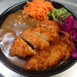 A plate of Japanese food , with breaded chicken, vegetables and a thick, brown sauce.