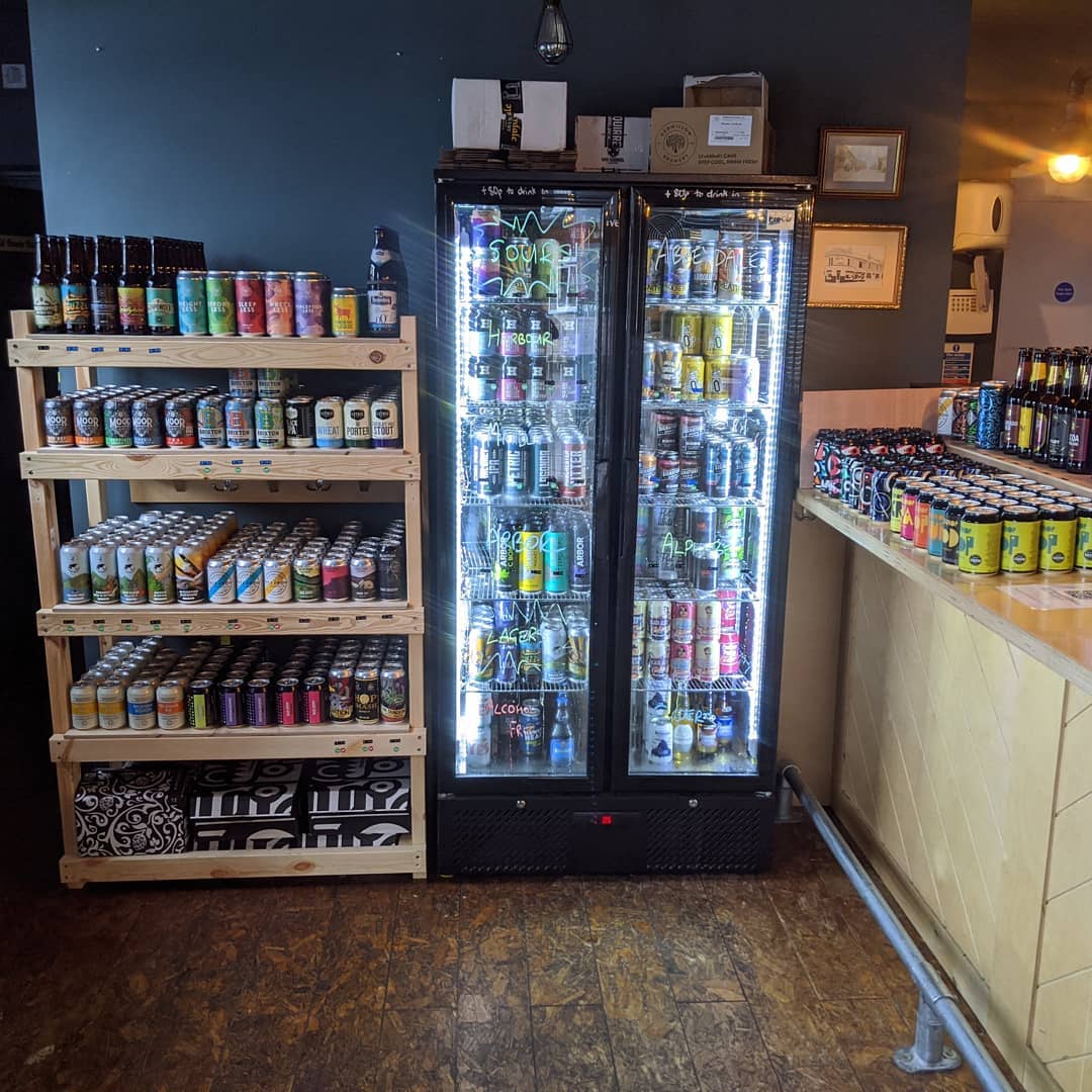 Shelves and fridges full of bottles and cans of beer.