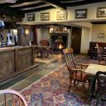 Rustic country inn bar with wooden furnishings, ambient lighting, and seating at Dog and Partridge.