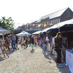 People looking through the stalls at Rex Market on a sunny day.