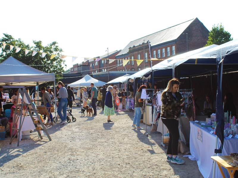 People looking through the stalls at Rex Market on a sunny day.