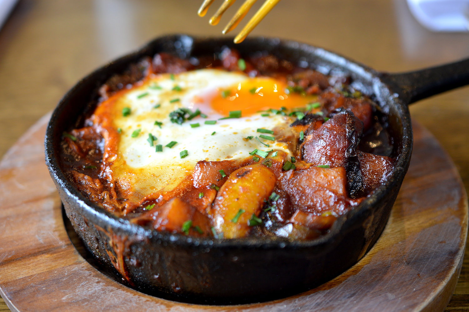 A close up of an iron skillet cooking food on a stove.