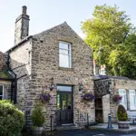 Exterior of The Cross Scythes pub showing the building and entrance.