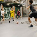 Four boys play indoor football at Yard Ball.
