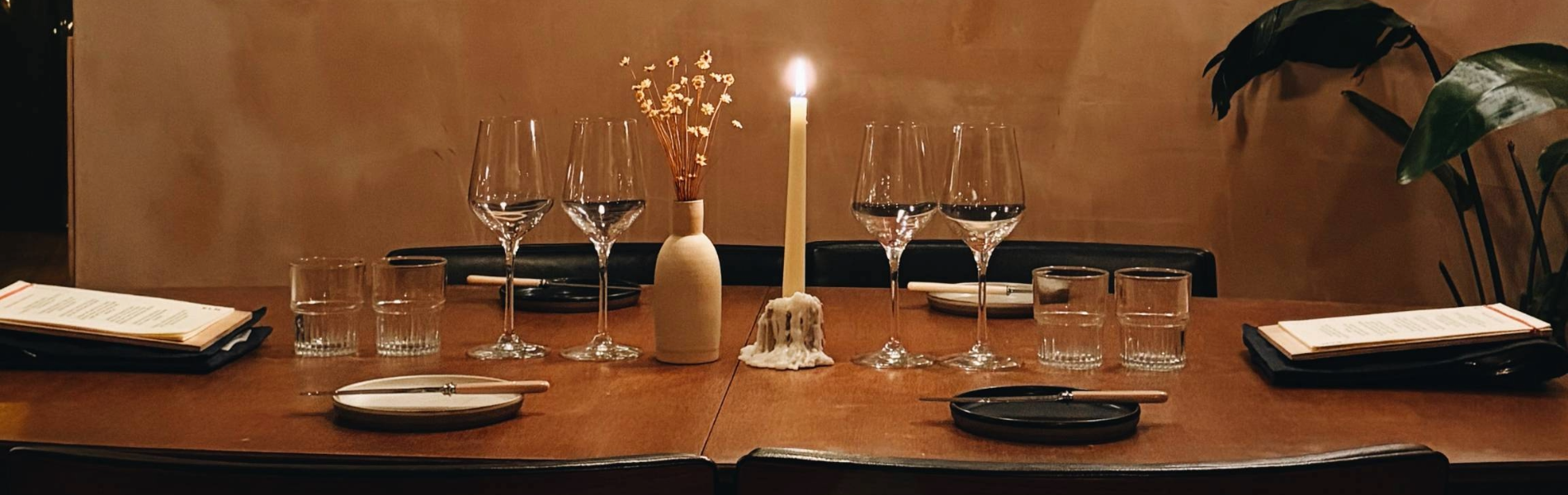 The interior of Restaurant Elm with a table laid out for two, under a large painting.
