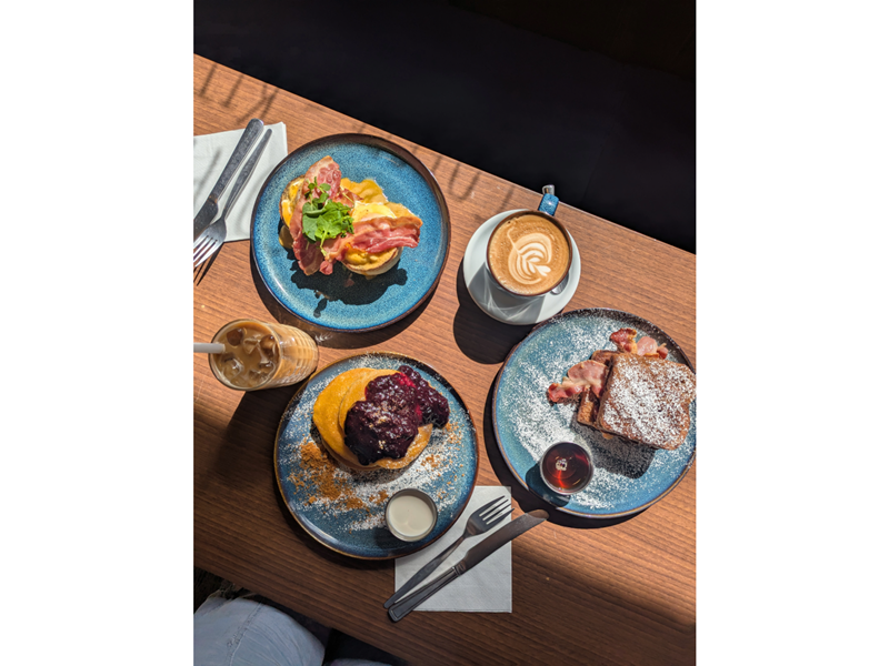 A lovely breakfast, set out on a wooden table in the sunshine, at the Copper Pot Café.