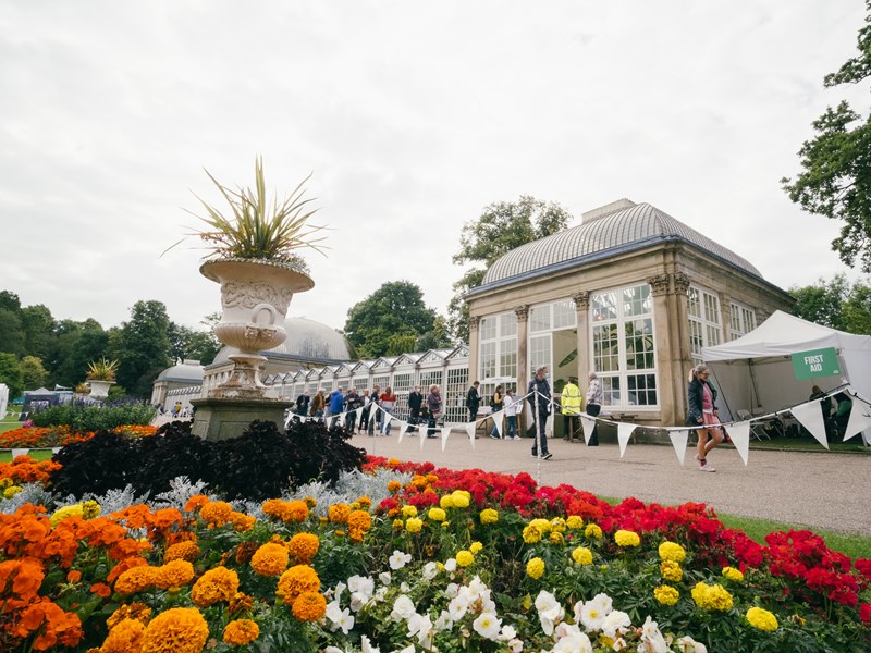 Flower beds in bloom in front of the Glass House at Sheffield Botanical Gardens.