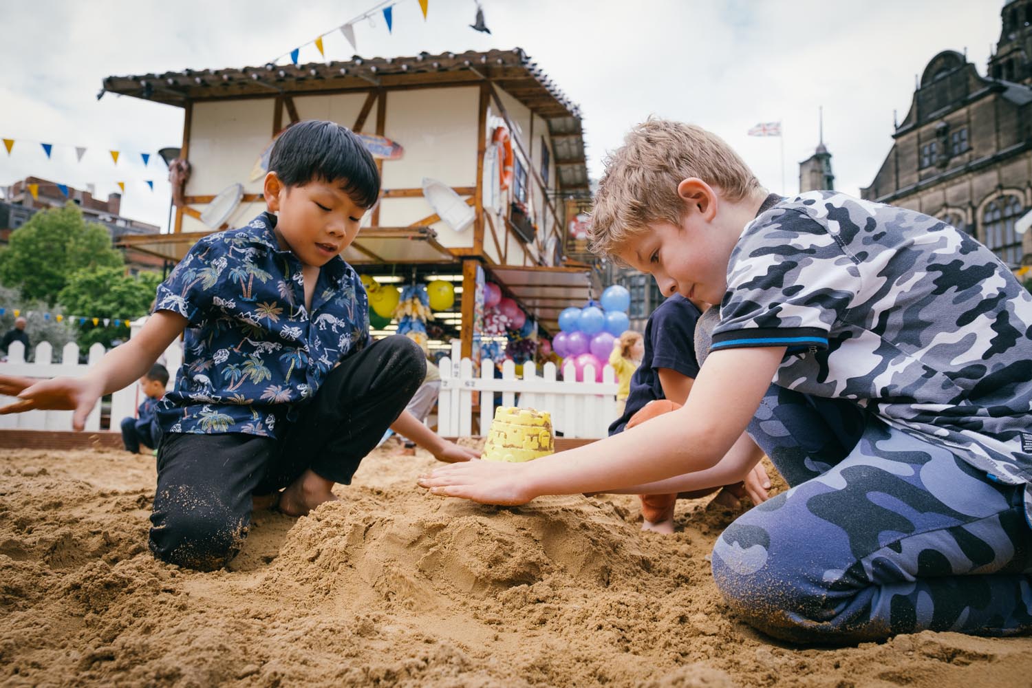 Children are playing in a sandpit that has been set up in the Peace Gardens in Sheffield city centre as part of the Sheffield By The Seaside event.