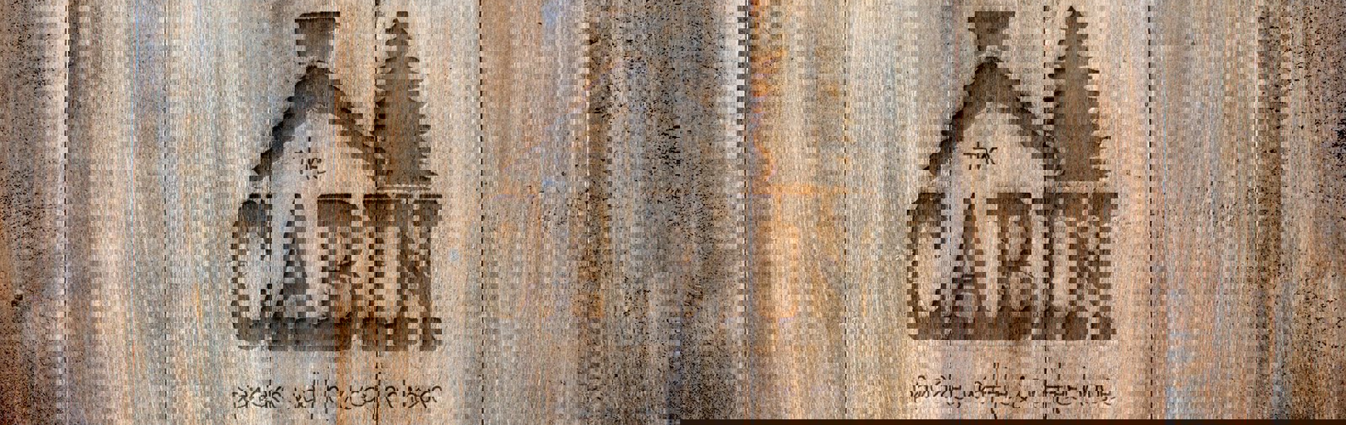 The Cabin logo on a wooden wall.