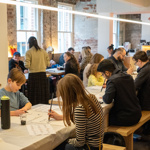 Rows of tables filled with people who are drawing and painting.