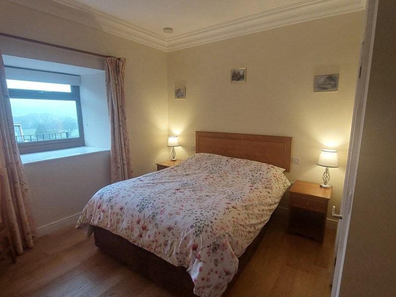 Padley Farm - bedroom with bed, bedside table, and simple furnishings.