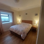 Padley Farm - bedroom with bed, bedside table, and simple furnishings.