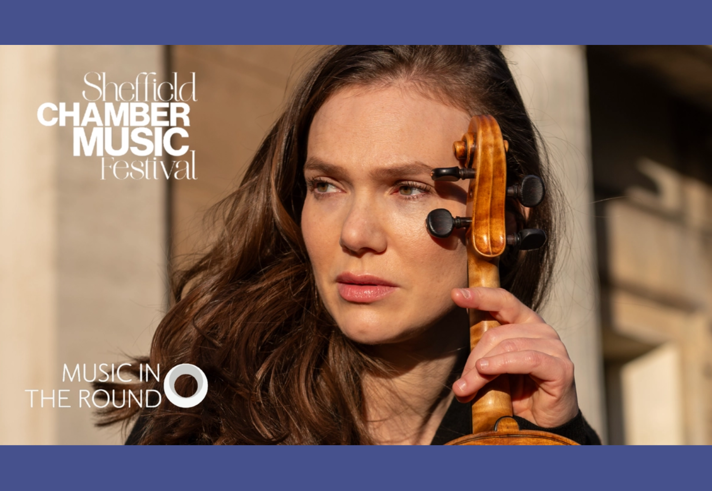 A headshot of a person holding a violin.