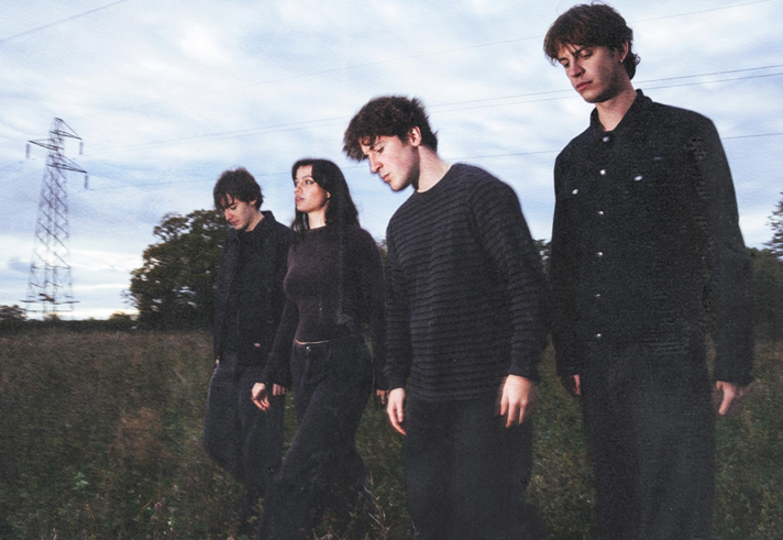 A group shot of Overpass walking through a field.