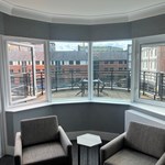 Bedroom with two cozy chairs and a window overlooking the balcony.