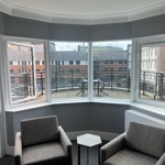 Bedroom with two cozy chairs and a window overlooking the balcony.