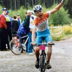A person elated to have finished a bike race.