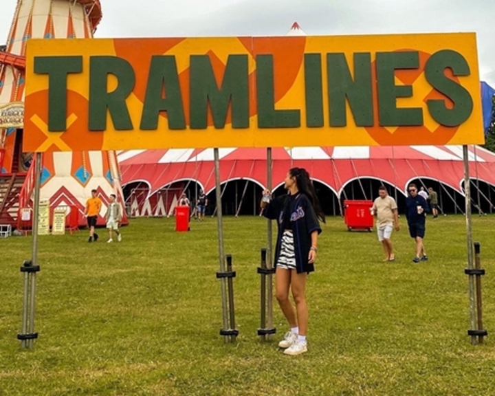 Joey from Sheffield Hallam University standing in front of a Tramlines Sign.