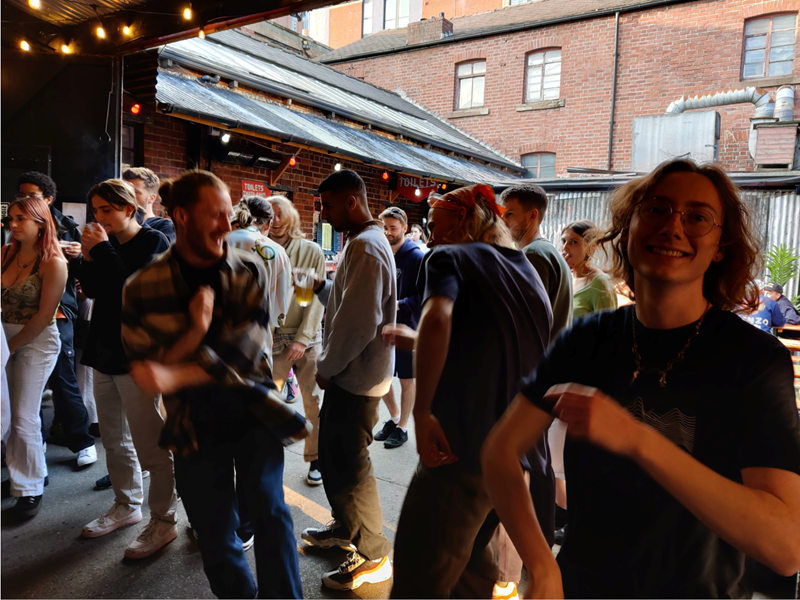 A group of people dancing at a night out.