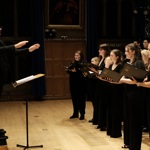 A choirs performs with a conductor. 