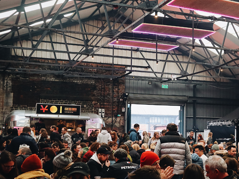 Peddler Market & Warehouse full of people sitting at long tables.