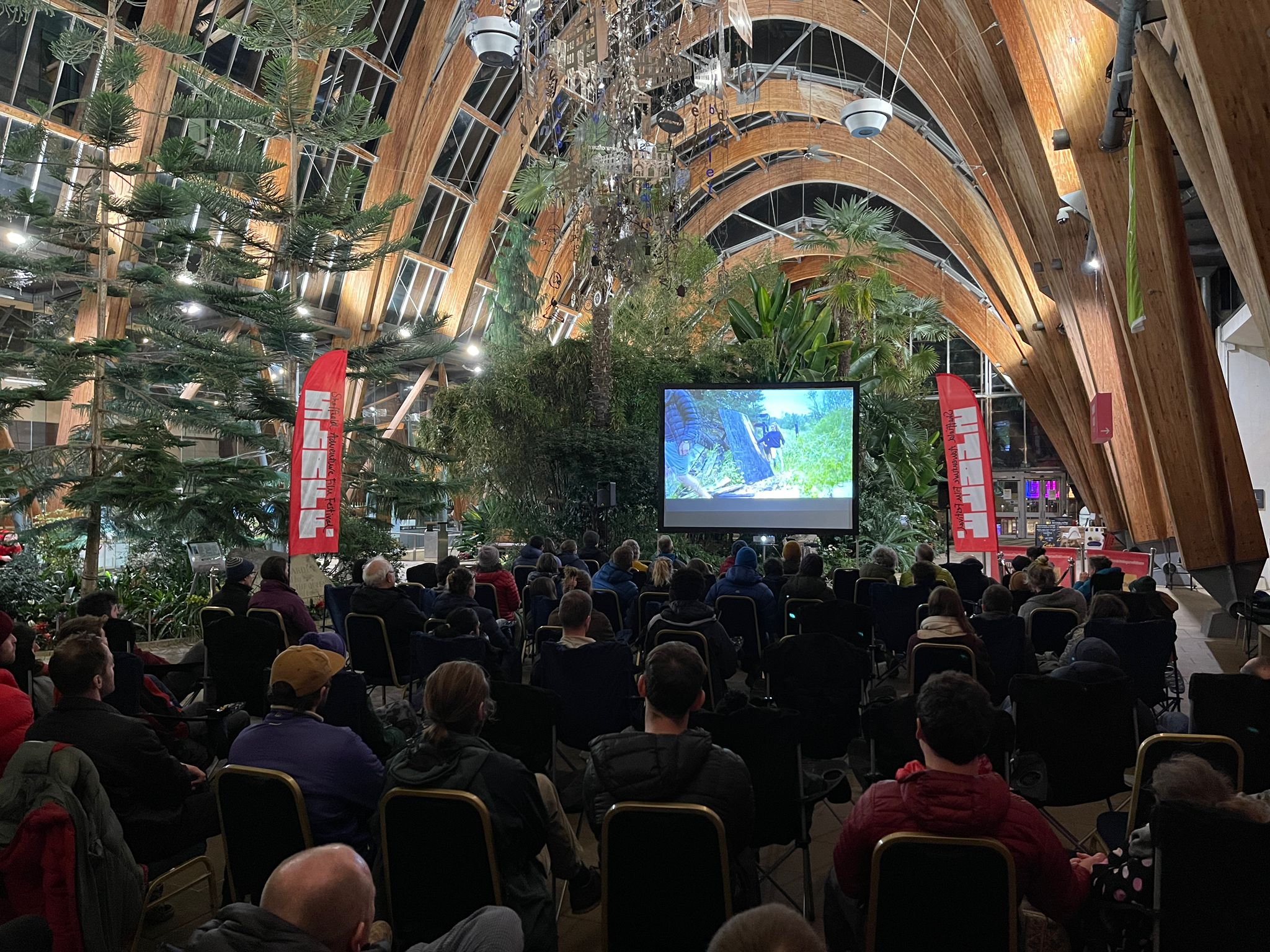 A large audience watch a film screening in the Winter Garden.