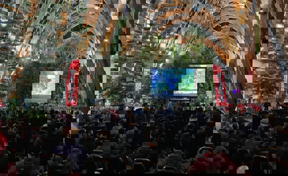 A large audience watch a film screening in the Winter Garden.