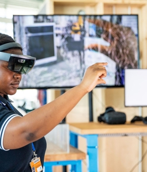 A female nurse uses a headset and enhanced-reality technology. 